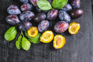 Siyah arka planda bir sürü taze erik. Boşluğu kopyala