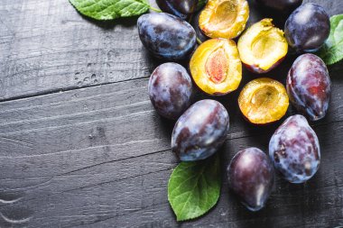 Siyah arka planda bir sürü taze erik. Boşluğu kopyala