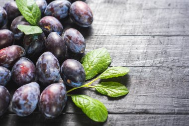 Siyah arka planda bir sürü taze erik. Boşluğu kopyala