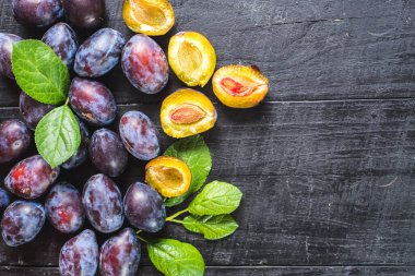 Siyah arka planda bir sürü taze erik. Boşluğu kopyala