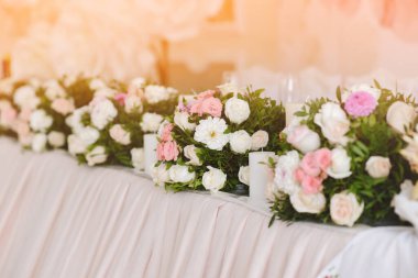 Düğün masasında bir sürü çiçek var.