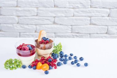 Böğürtlenli tatlı bardaklar ve beyaz üzümlü üzümler. Tiramisu ve pannacota