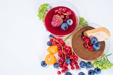 Böğürtlenli tatlı bardaklar ve beyaz üzümlü üzümler. Tiramisu ve pannacota