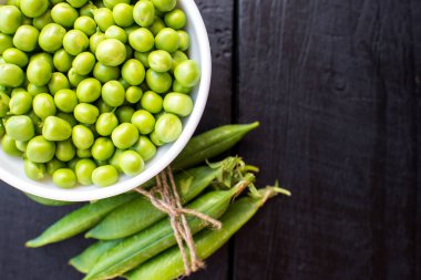 Ahşap arka planda bir kasede bezelye tohumu. Boşluğu kopyala
