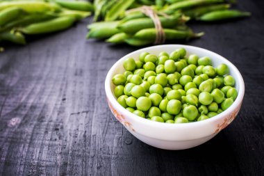 Ahşap arka planda bir kasede bezelye tohumu. Boşluğu kopyala