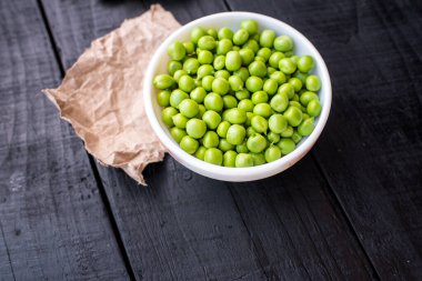 Ahşap arka planda bir kasede bezelye tohumu. Boşluğu kopyala