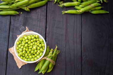 Ahşap arka planda bir kasede bezelye tohumu. Boşluğu kopyala