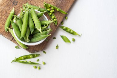 Tahta üzerinde beyaz bir bezelye kabuğu. Boşluğu kopyala