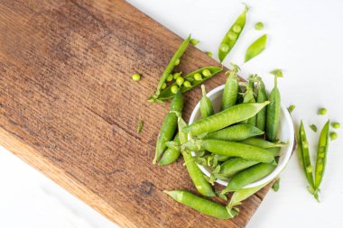 Tahta üzerinde beyaz bir bezelye kabuğu. Boşluğu kopyala