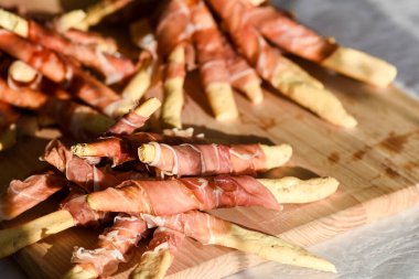 Lezzetli ekmek çubukları ve masada jambon.