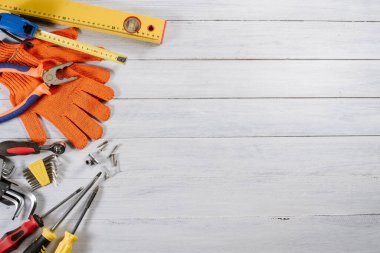 Beyaz ahşap arka planda farklı bina ya da zanaat araçları ve eldivenler düzleştirilmiş