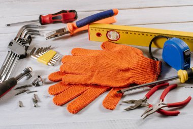 Beyaz ahşap arka planda farklı bina ya da zanaat araçları ve eldivenler düzleştirilmiş