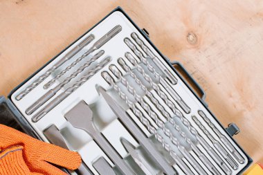 Ahşap arka planda farklı metalik matkaplar var.