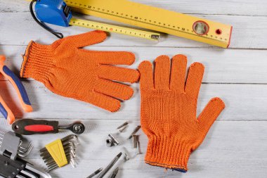 Beyaz ahşap arka planda farklı bina ya da zanaat araçları ve eldivenler düzleştirilmiş