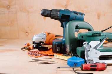 Tahta arka planda elektrikli bina ve el işi aletleri ve araçlar