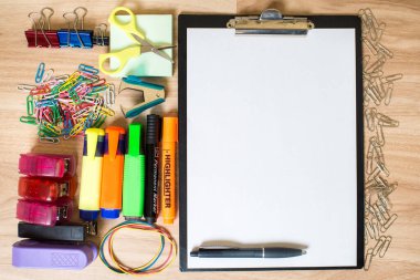 Masanın üzerinde bir fincan kahve ve farklı ofis aletleri olan boş beyaz bir kağıt.