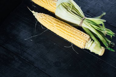 Siyah arka planda çiğ mısır. Boşluğu kopyala