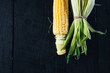 Siyah arka planda çiğ mısır. Boşluğu kopyala