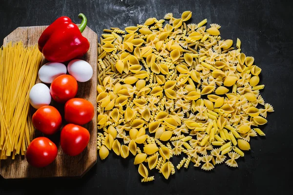 A variety on raw pasta on black background