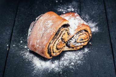 Siyah arka planda haşhaş tohumlu tatlı çörekler.