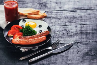 Tavada sosisli omlet ve siyah arka planda domates suyu. Boşluğu kopyala