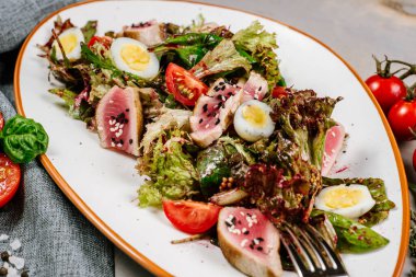 Ahşap arka planda et ve sebzeli lezzetli taze salata.