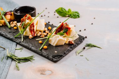 Ahşap zemin üzerinde farklı peynir, bal ve baharatlar olan bir yemek.