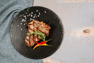 Ahşap arka planda baharatlı leziz biftek.