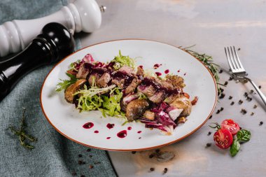 Ördek etli, soslu ve ahşap arka planda baharatlı bir tabak.