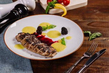 Ahşap arka planda meyve soslu ızgara et.