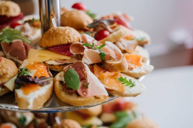 Büfede atıştırmalık bir sürü küçük hamburger var.