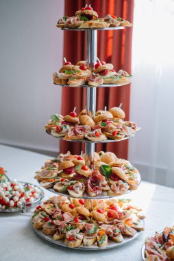 Büfede atıştırmalık bir sürü küçük hamburger var.