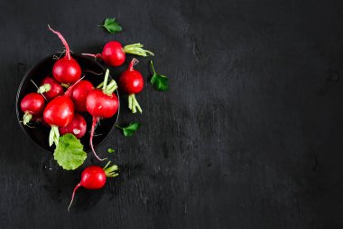 Siyah ahşap kaplamalı taze kırmızı turp.