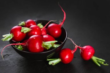 Siyah ahşap kaplamalı taze kırmızı turp.