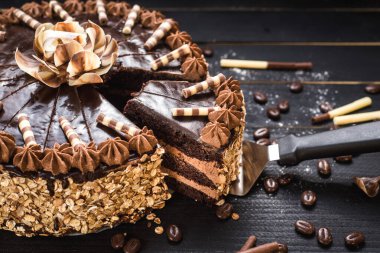 Siyah ahşap arka planda lezzetli kremalı tatlı çikolatalı pasta.