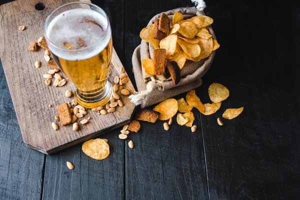 Ein Glas Frisches Bier Mit Kartoffelchips Und Erdnüssen Auf Schwarzem Stockbild