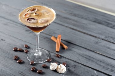 Tahta arka planda bardakta kahve ile alkol kokteyli.