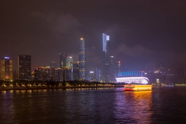 Gece gökdelenler ile modern şehir. Köprü Nehri üzerinde şehir binaları geceleri parlayan. Quay ağaçlarıyla, Parlatıcı ışıklar. Guangzhou gece city iş merkezi.