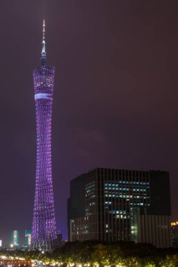 Guangzhou gece yüksek renk Tv Kulesi. Gece gökyüzünde yüksek keskin sivri kule parlak ışıkları. Bulutlar uçan yüksek modern kule.