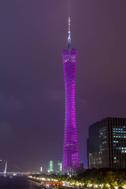 Guangzhou gece yüksek renk Tv Kulesi. Gece gökyüzünde yüksek keskin sivri kule parlak ışıkları. Bulutlar uçan yüksek modern kule.