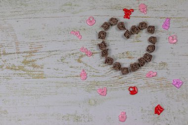 Kalp karanlık GÜL oyuncaklar ile yapılmış. Ahşap arka plan üzerinde Yukarıdaki fotoğraf. Aşk, Sevgililer Günü Bayramı. Kartpostal kopya alanı ile.