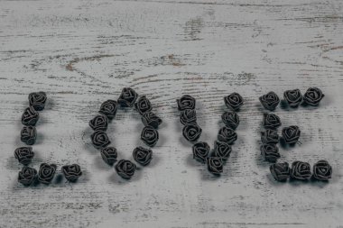 Gül ahşap arka plan, bokeh yan görünüm üzerinde koyu kahverengi aşk mektupları. Metin aşk merkezinde ahşap arka plan üzerinde. Tatil sevgili için tebrikler.