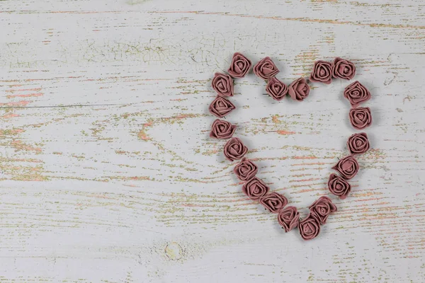 Kahverengi gül yapılan kalp. Ahşap arka plan üzerinde Yukarıdaki fotoğraf. Aşk, Sevgililer Günü Bayramı. Kartpostal kopya alanı ile.