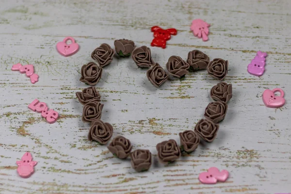 Kalp karanlık GÜL oyuncaklar ile yapılmış. Ahşap arka plan üzerinde bokeh fotoğraf. Aşk, Sevgililer Günü Bayramı. Kartpostal kopya alanı ile.