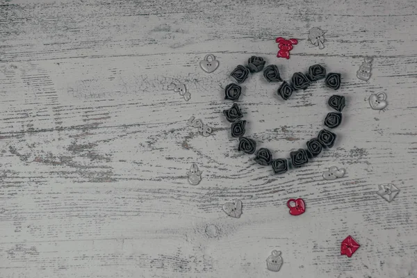 Kalp karanlık GÜL oyuncaklar ile yapılmış. Ahşap arka plan üzerinde Yukarıdaki fotoğraf. Aşk, Sevgililer Günü Bayramı. Kartpostal kopya alanı ile.