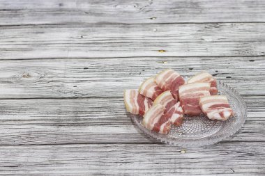 Cam plaka üzerinde domuz göbek kıyılmış küçük parçalar. Pastırma Juicy parçaları.