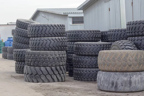 रस्त्यावर पडलेल्या ट्रकसाठी मोठ्या रबर टायर. ब्लॅक टायर्स मोठ्या चादरीसह नवीन आणि जुने बंद . — स्टॉक फोटो, इमेज