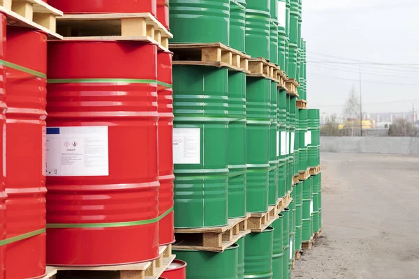 Barriles de 200 litros de metal están en el palet de la calle. Barriles rojos y verdes para petróleo, productos químicos, gasolina. Primer plano . — Foto de Stock