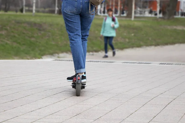 A menina monta em uma scooter elétrica. Transporte ecologicamente correto. Estilo de vida ativo moderno . — Fotografia de Stock