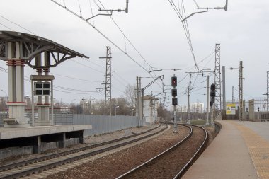 Trensiz şehirde demiryolu platformu. Demir yollar arasında büyük bir trafik ışığı duruyor.